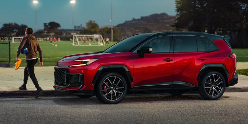 RAV4-PLUG-IN-HYBRID SUV parked near a sports field.