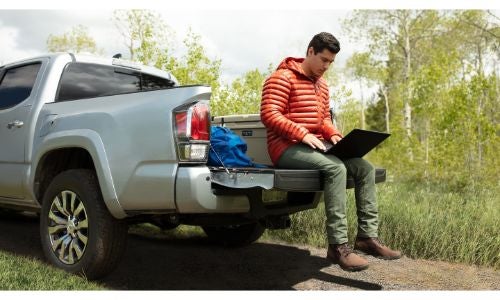 2020 Toyota Tacoma grey tailgate down man on laptop