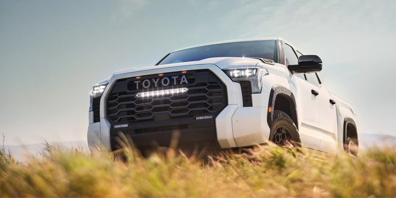 An all-new white 2025 Toyota Tundra parked in a long grass field. - Phil Meador Toyota Pocatello, ID