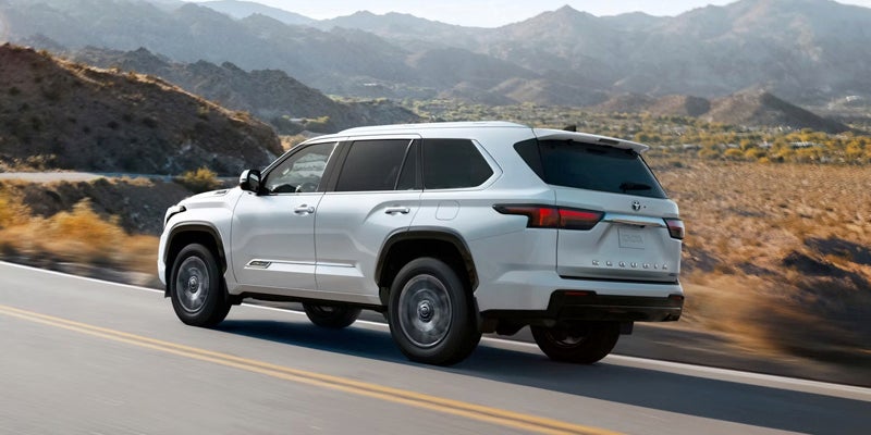 An all-new white 2025 Toyota Sequoia driving a desert mountain highway. - Phil Meador Toyota Pocatello, ID
