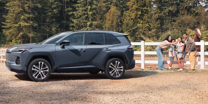 2026 Toyota RAV4 parked near family outdoors.