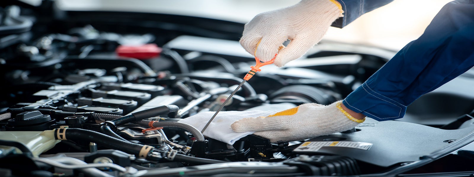 Automotive technician checking engine fluids