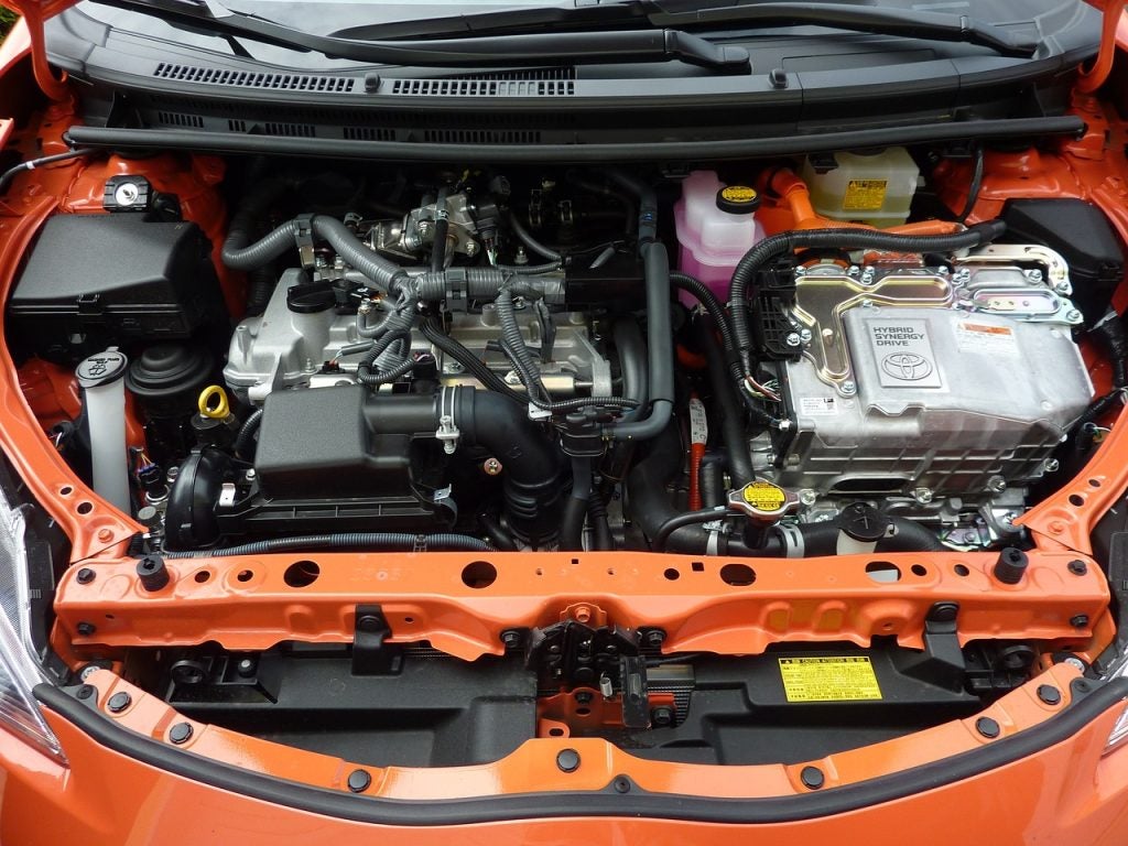 Under the hood of an orange Toyota model vehicle looking at the engine bay. At the Phil Meador Toyota shop in Pocatello, ID.