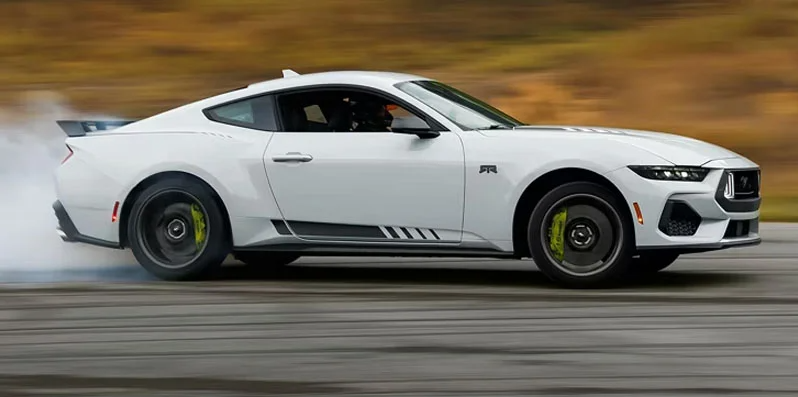 A white 2026 Ford Mustang driving down the road.