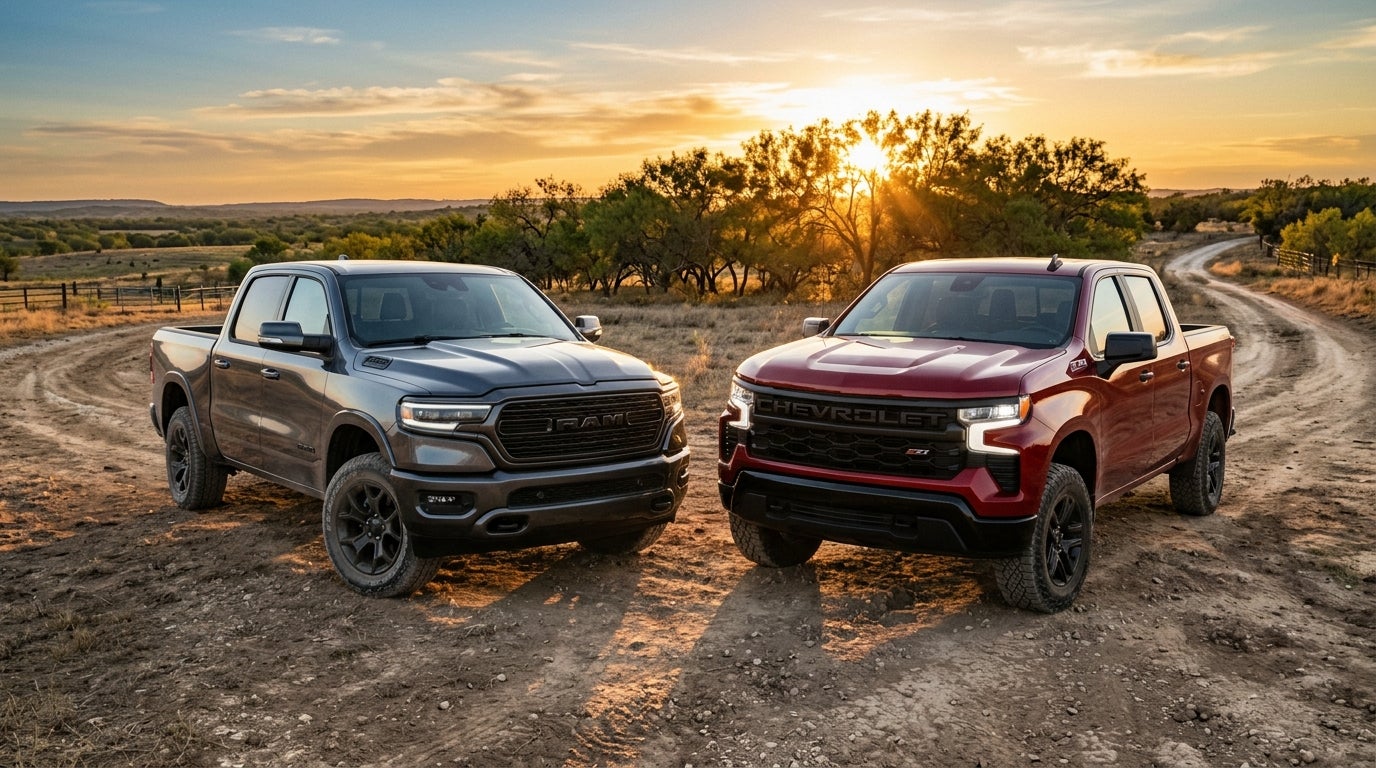 A gray Ram truck and a red Chevrolet Silverado parked side-by-side on a dirt path during a golden sunset. (Representative image for illustration purposes only. Actual vehicle may vary based on trim and configuration.)