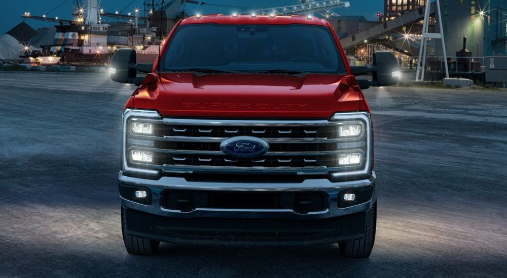Red 2026 Ford F-250 parked on a construction site at night.