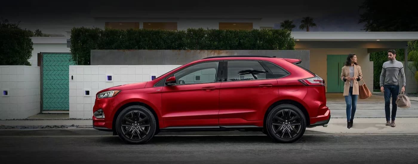 Two people near a red 2024 Ford Edge.