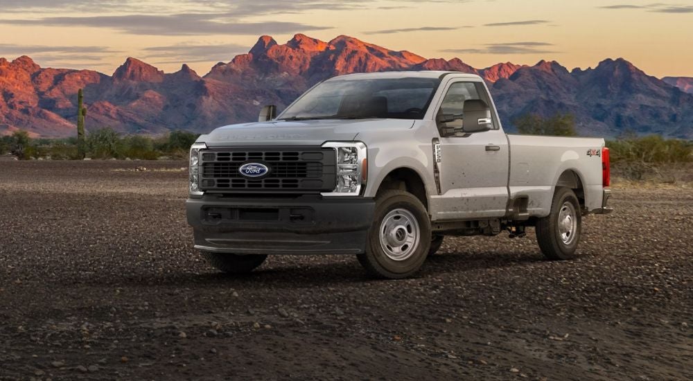 White 2026 Ford F-250 parked in the desert at sunset.
