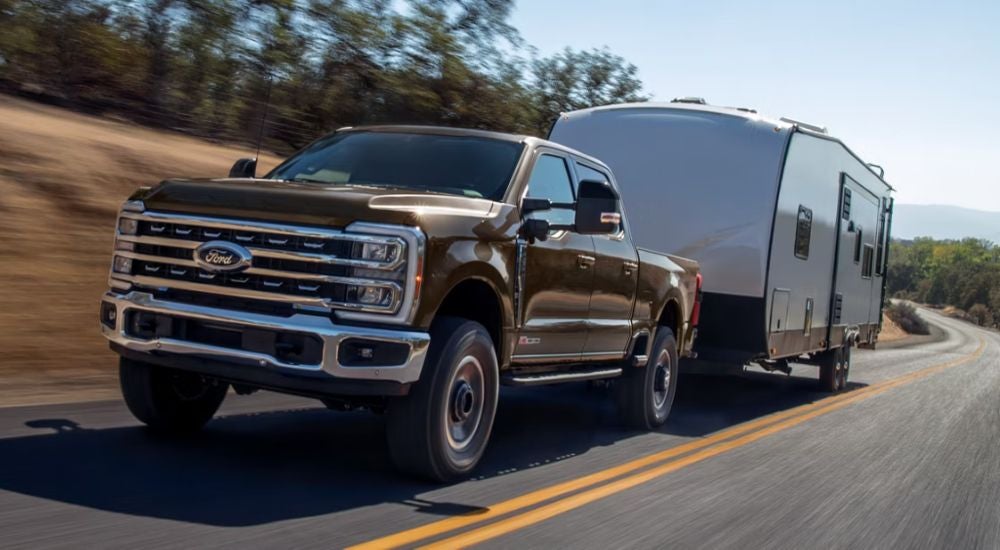 Brown 2026 Ford F-250 4-Door towing a trailer.