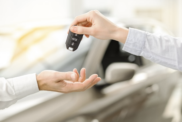Dealership representative handing car keys to customer