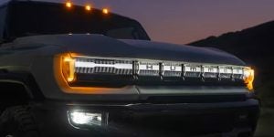 2024 GMC Hummer EV parked with front lights on.