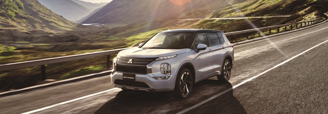 White 2024 Mitsubishi Outlander Plug-In Hybrid Driving on Road