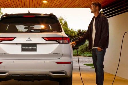 Man Charging 2024 Mitsubishi Outlander Plug-In Hybrid SUV