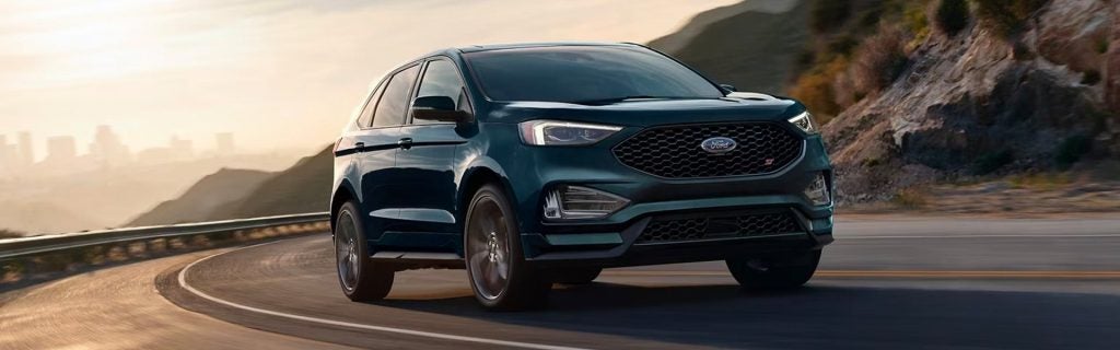 Blue 2024 Ford Edge driving a scenic route
