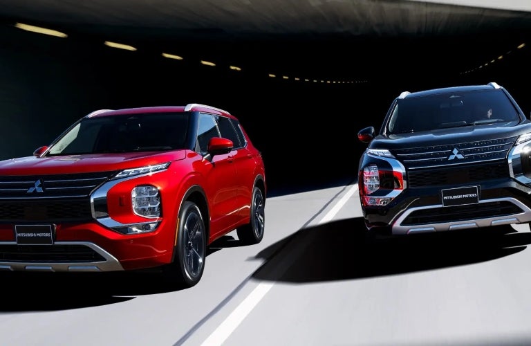 Two Mitsubishi Outlanders Driving on Road Side by Side