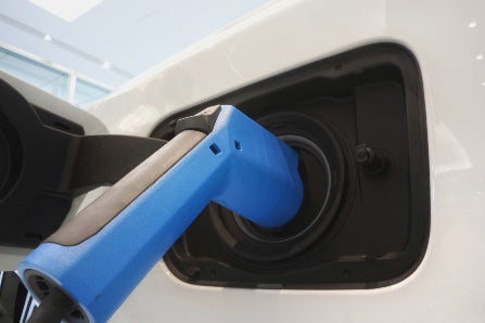 Blue EV Charger Plugged In to White EV