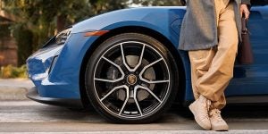 A person standing beside a 2024 Porsche Taycan. 