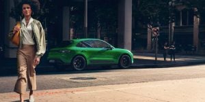2024 Porsche Macan driving through town.