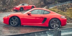 A person driving a 2025 Porsche 718 Cayman up the mountain side.