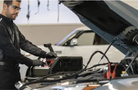 INFINITI technician inspecting battery
