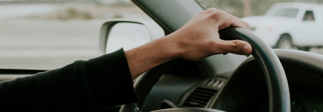 Hand on Car's Steering Wheel