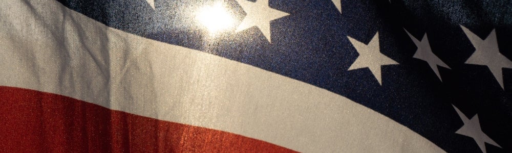 American flag with sun shining through