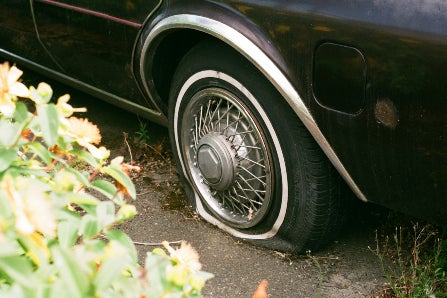 Flat tire on car parked in dirt