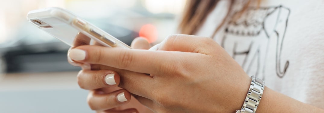 Woman with painted nails holding cell phone