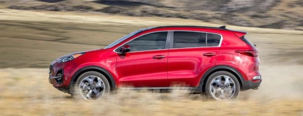 Sideview of a 2022 Kia Sportage cruising down a dusty road