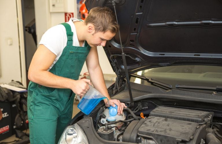 Technician pouring coolant