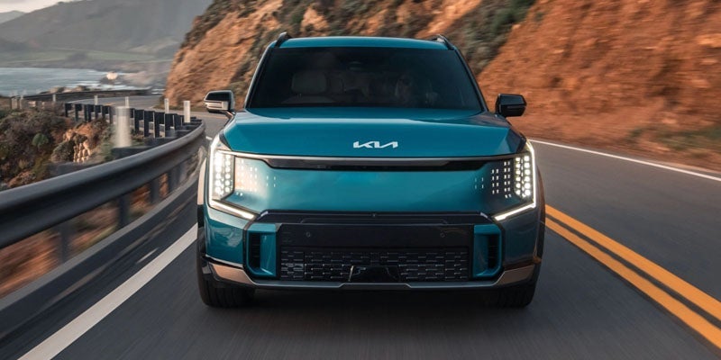 A 2024 Kia EV9 driving on a picturesque highway near Hayward, CA 