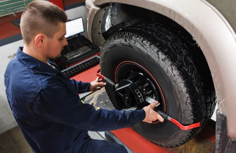 mechanic performing wheel alignment