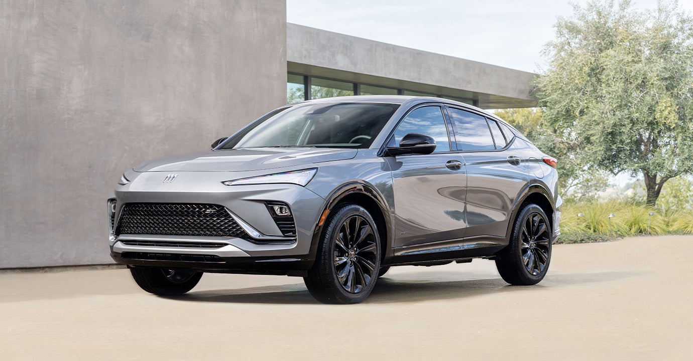 Front driver's side view of a silver 2025 Buick Envista parked in a driveway on a sunny day