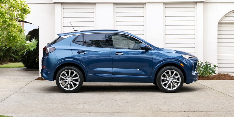 Passenger side view of a blue 2025 Buick Encore GX parked in a residential driveway