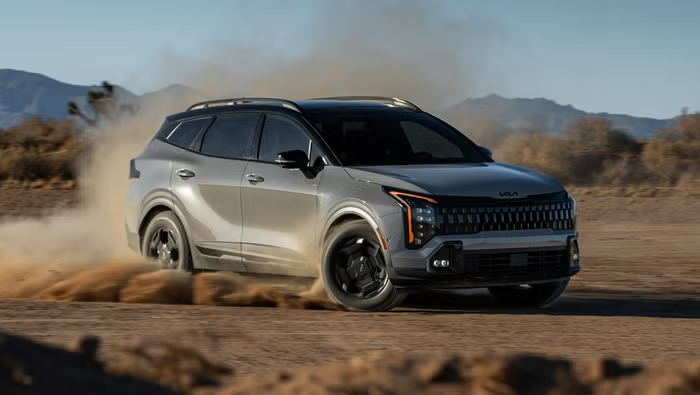 Kia Sportage SUV driving through a desert road