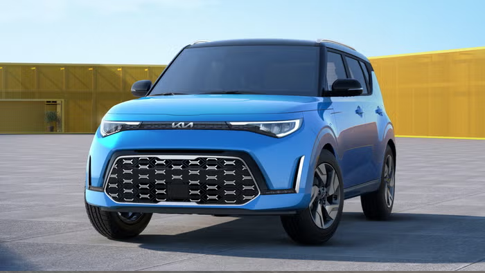 Blue Kia Soul compact SUV parked in front of a yellow wall