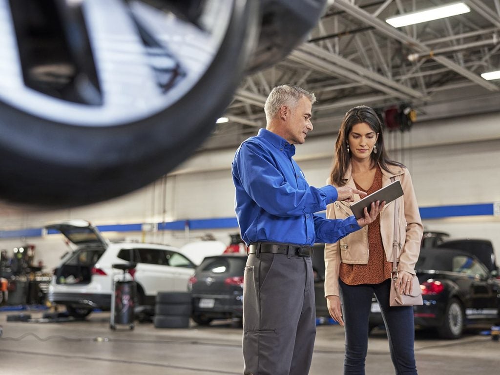 Volkswagen service technician reviewing maintenance recommendations with a customer