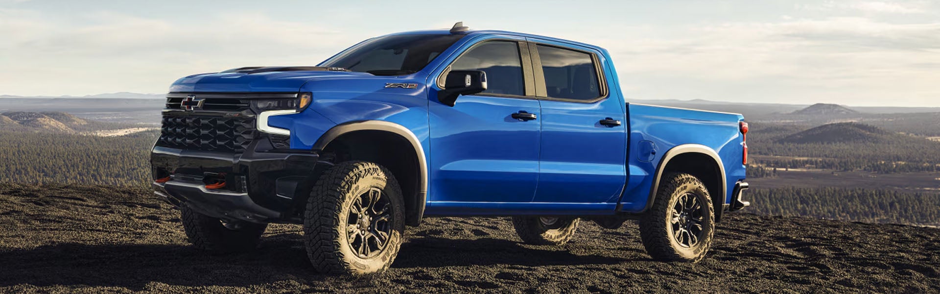 Blue Chevrolet Silverado truck on a scenic overlook.