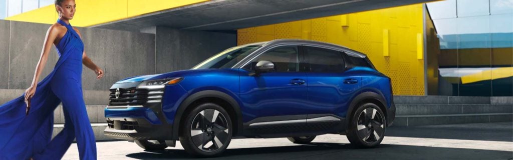 Blue SUV with woman walking by.