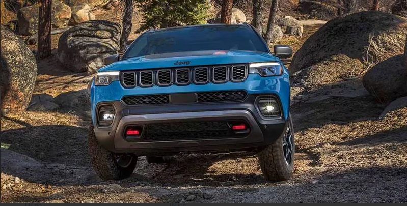 A blue 2026 Jeep Compass off-roading.