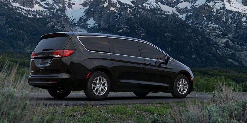 2026 Black Chrysler Voyager Parked in it's back side profile in between mountains