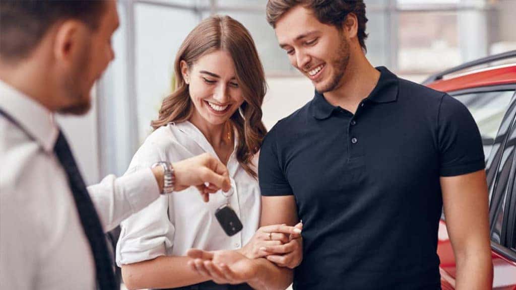Salesman handing keys to happy customer