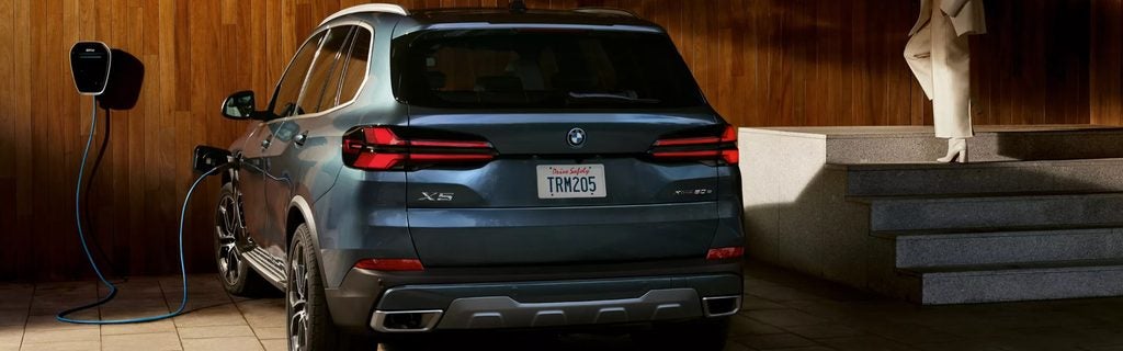 BMW X5 xDrive50e charging at a home charging station.