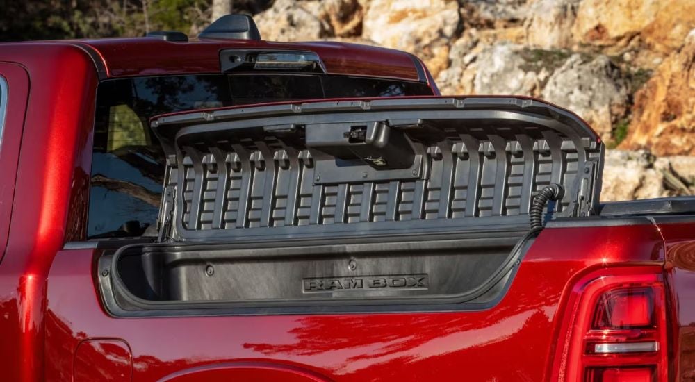The RamBox Cargo Management System with lid open on a red 2026 Ram 1500 Tungsten.