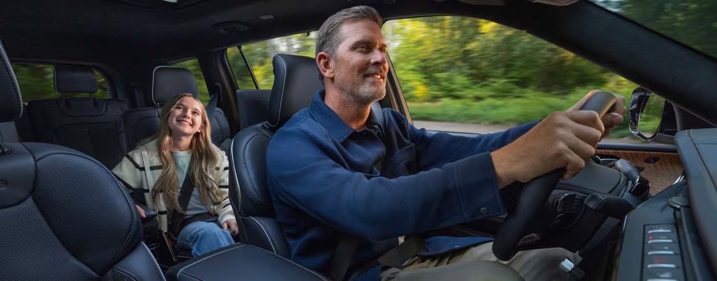 A person driving in a 2026 Jeep Grand Cherokee.