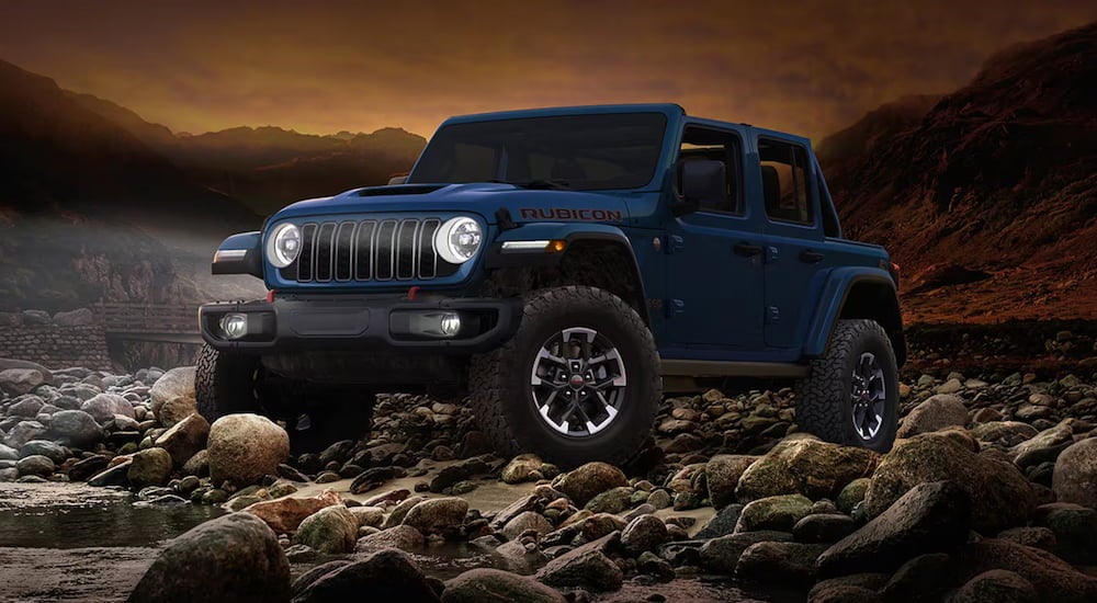 Dark blue 2026 Jeep Wrangler parked off-road.