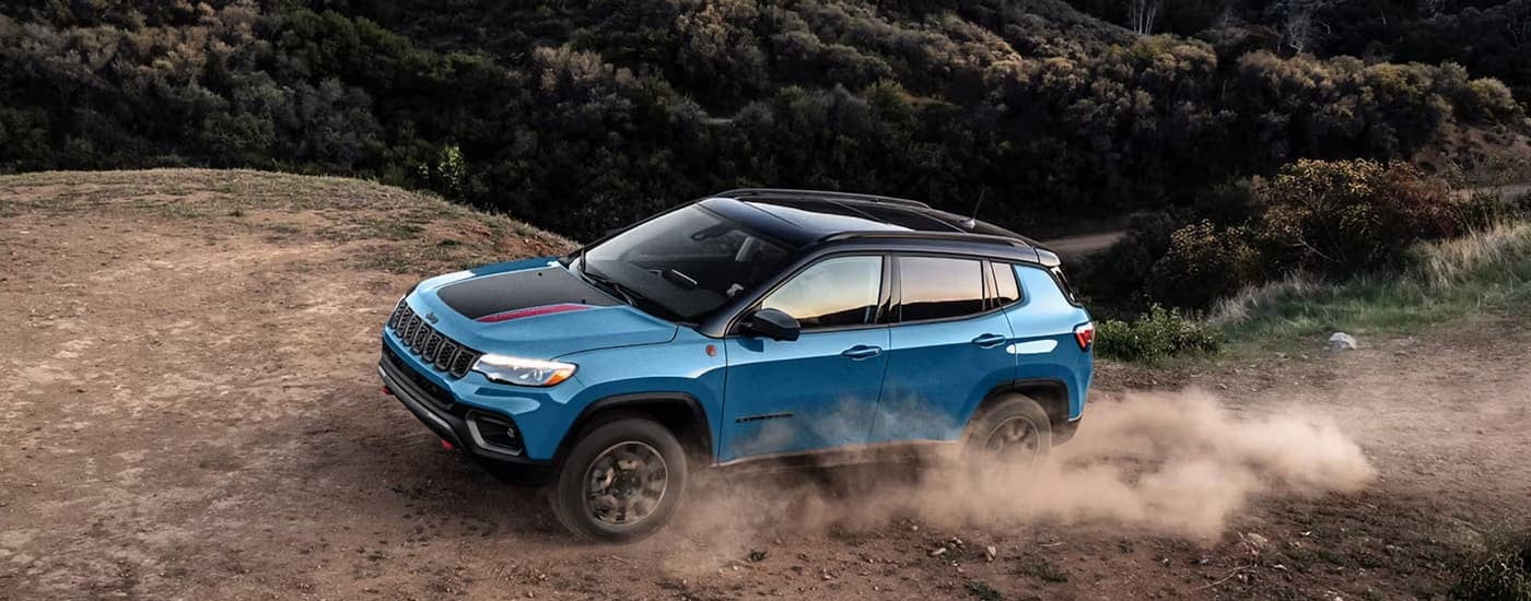 A blue 2026 Jeep Compass Trail Hawk off-roading.
