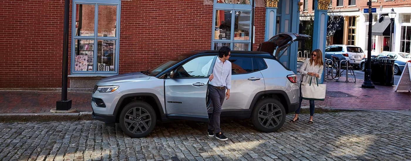 A silver 2026 Jeep Compass parked in a city.