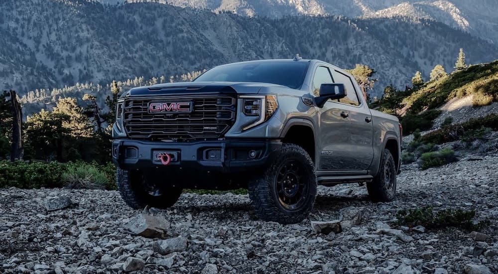 A grey 2024 GMC Sierra 1500 is shown parked off-road.