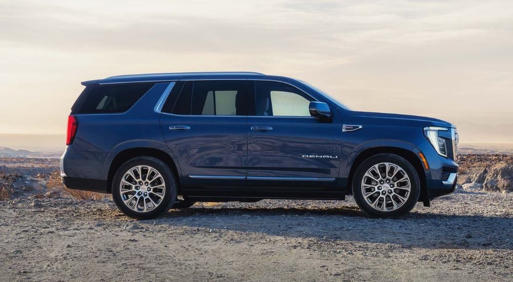 Blue 2027 GMC Yukon Denali off-road in the desert.